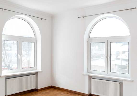 Bright interior room with two arched white-framed windows allowing natural light and outdoor views, highlighting elegant design, energy efficiency, and professional Window Replacement Alpharetta services for modern homes.