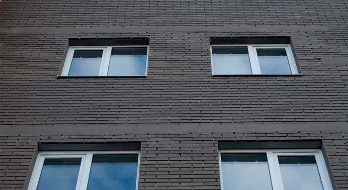 Interior bay window with white frames and decorative accents overlooking brick apartment buildings, enhancing natural light and city views while showcasing professional Window Replacement Atlanta services for modern, energy-efficient homes.
